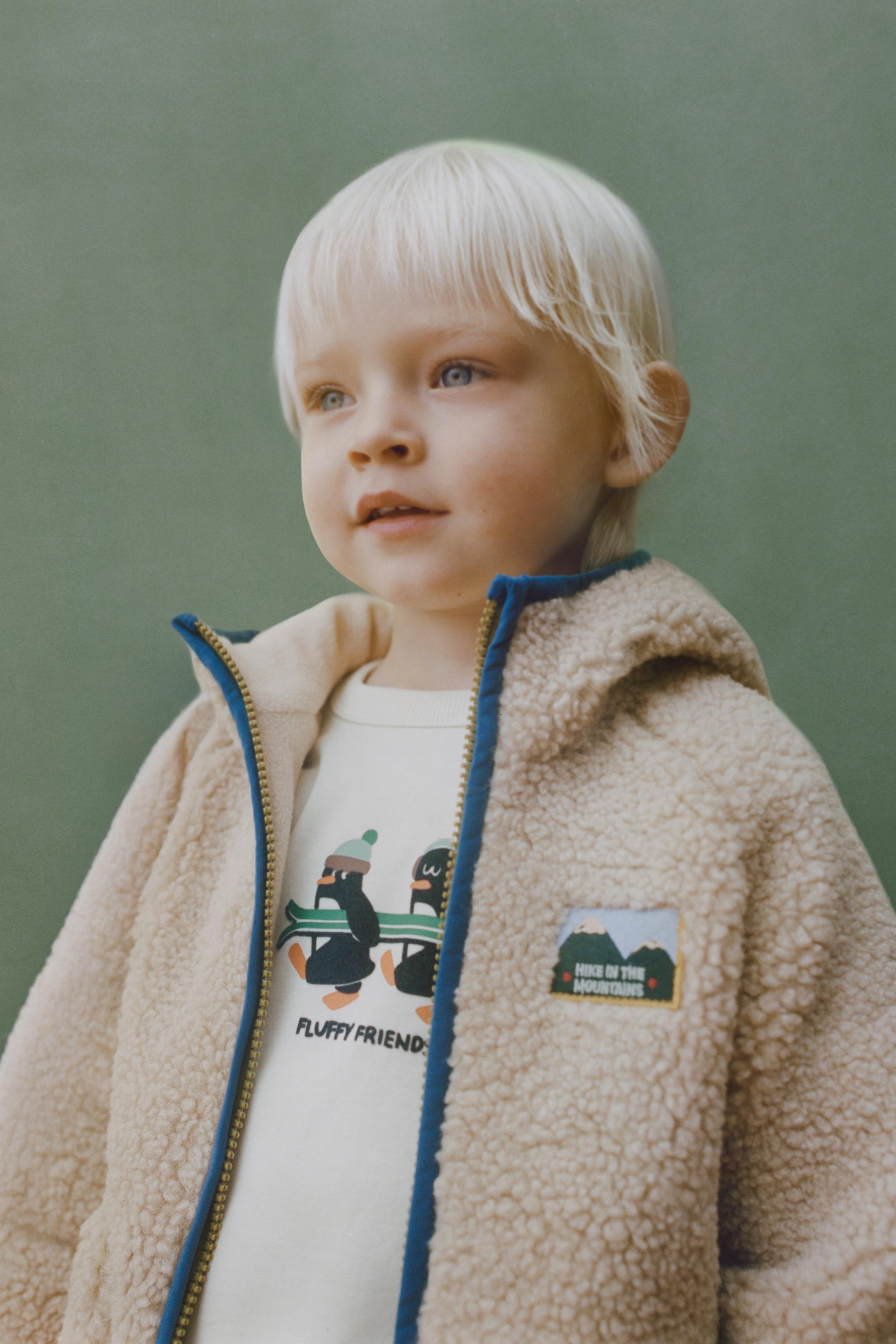 VESTE EFFET MOUTON CAPUCHE LISERÉS CONTRASTE